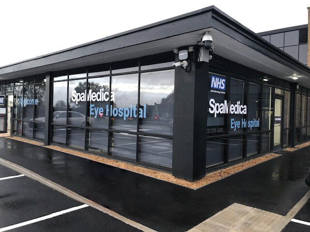 SpaMedica Eye Hospital in Preston, a single-storey building with a dark frame and glazed frontage, seen from the corner